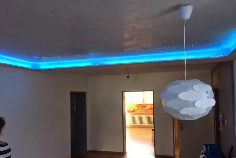 Wohnzimmer mit abgehängter Decke und blauem Licht
