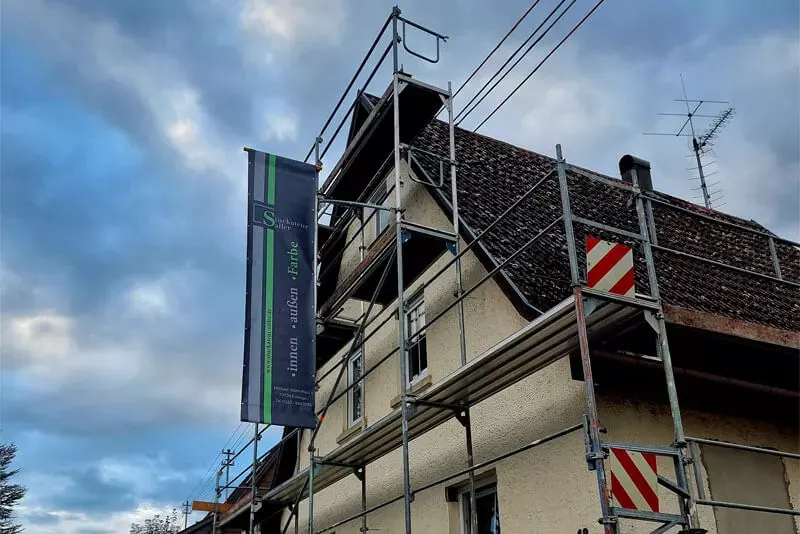 Altes Haus mit Gerüst vor blauem Himmel