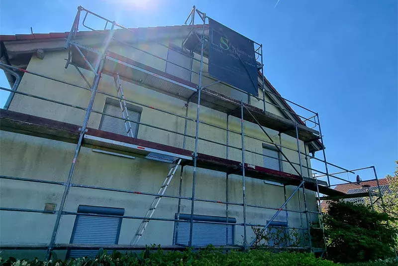 Eingerüstetes Haus mit Schutznetz